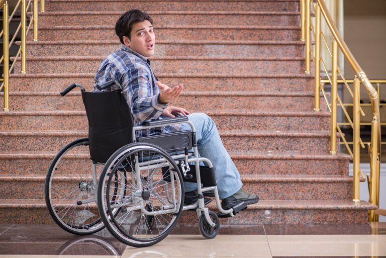 Best Portable Wheelchair Ramps - man in Wheelchair at the bottom of stair case