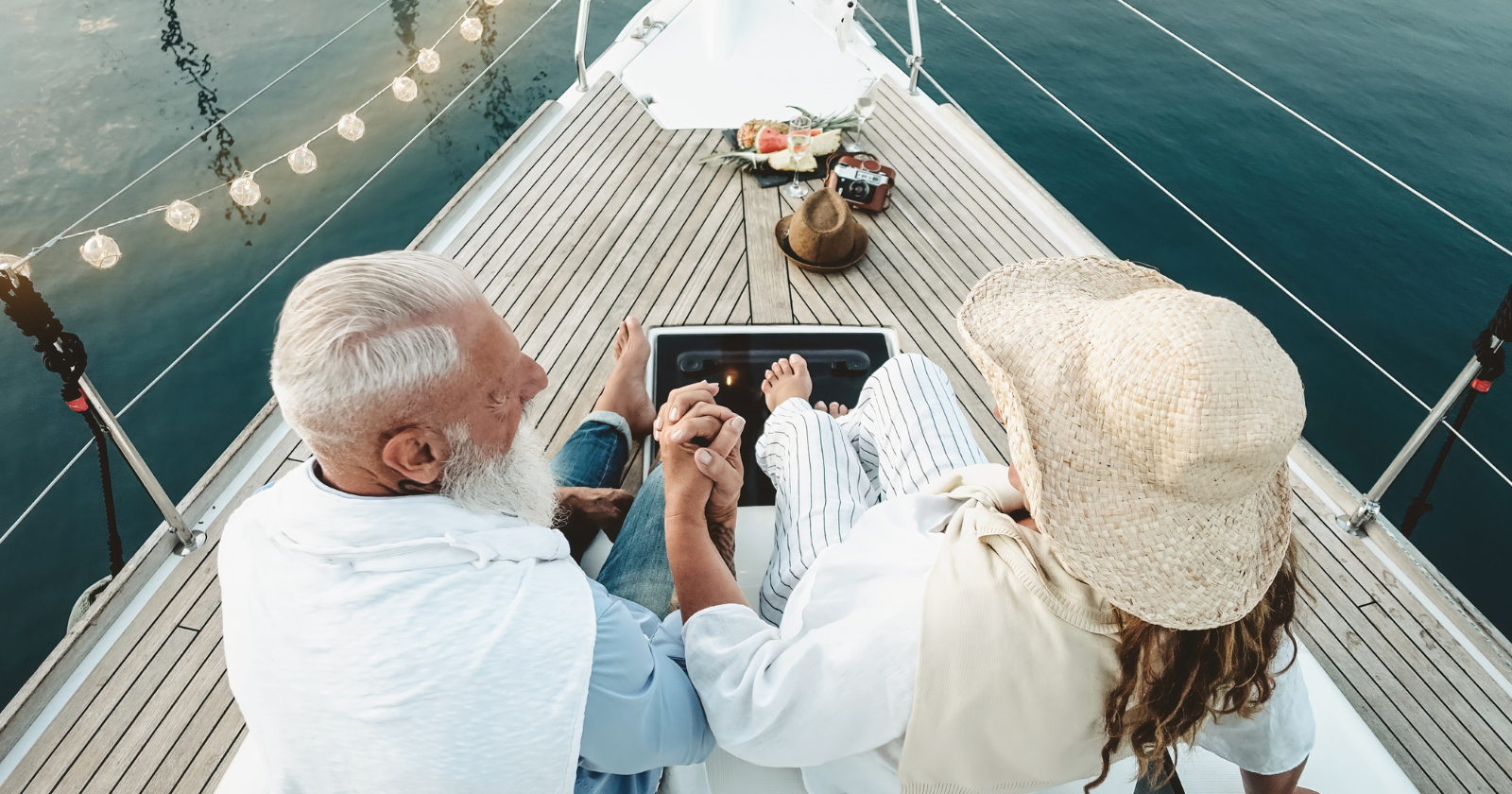 Senior couple toasting champagne on sailboat vacation