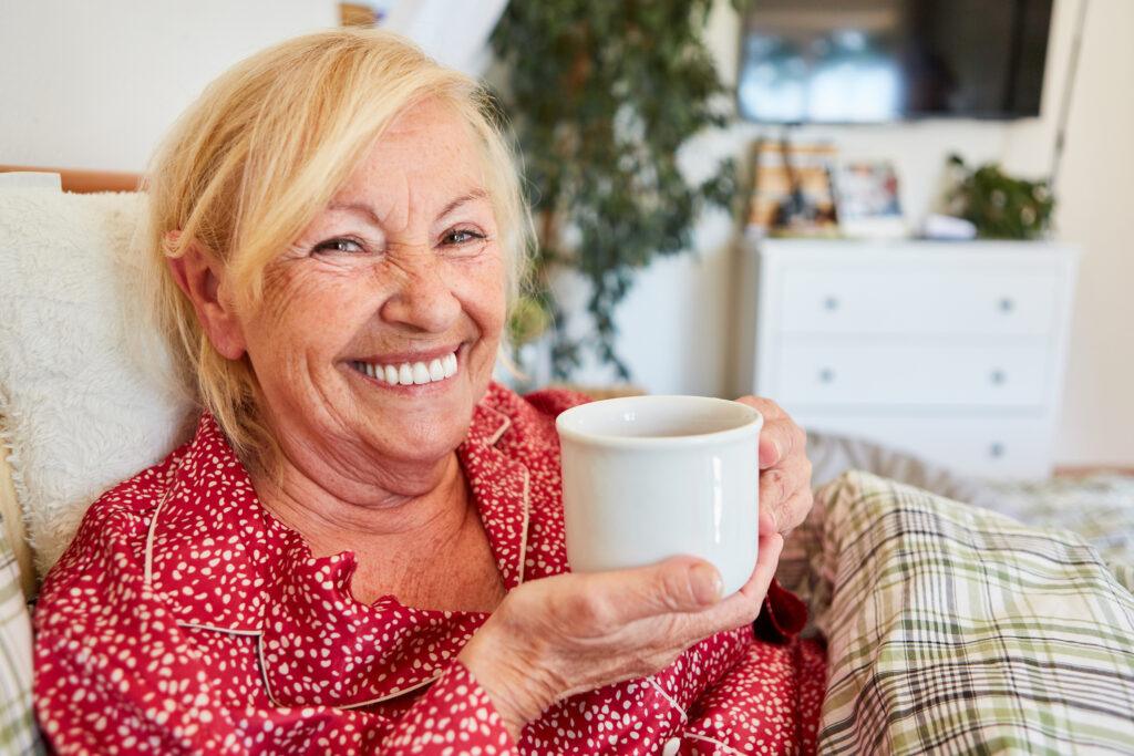 Seniorss lady drinking coffee in bed
