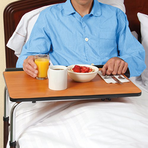 Man in bed eating off an over the bed table