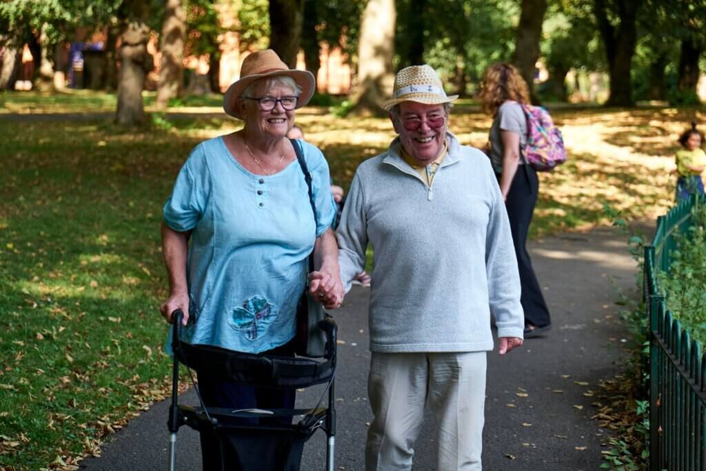 Couple enjoying the afternoon out in the park the woman using a walker