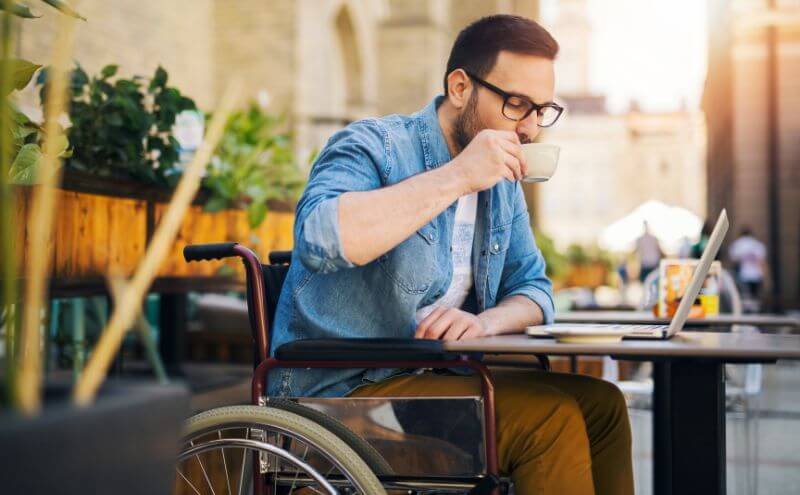 Disabled man drinking coffee in a wheelchair