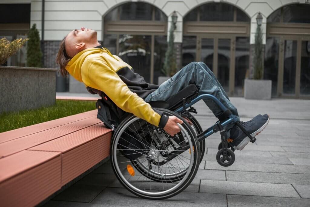 Person using a wheelchair outdoors to maintain independence and mobility with supportive mobility aids for everyday life.