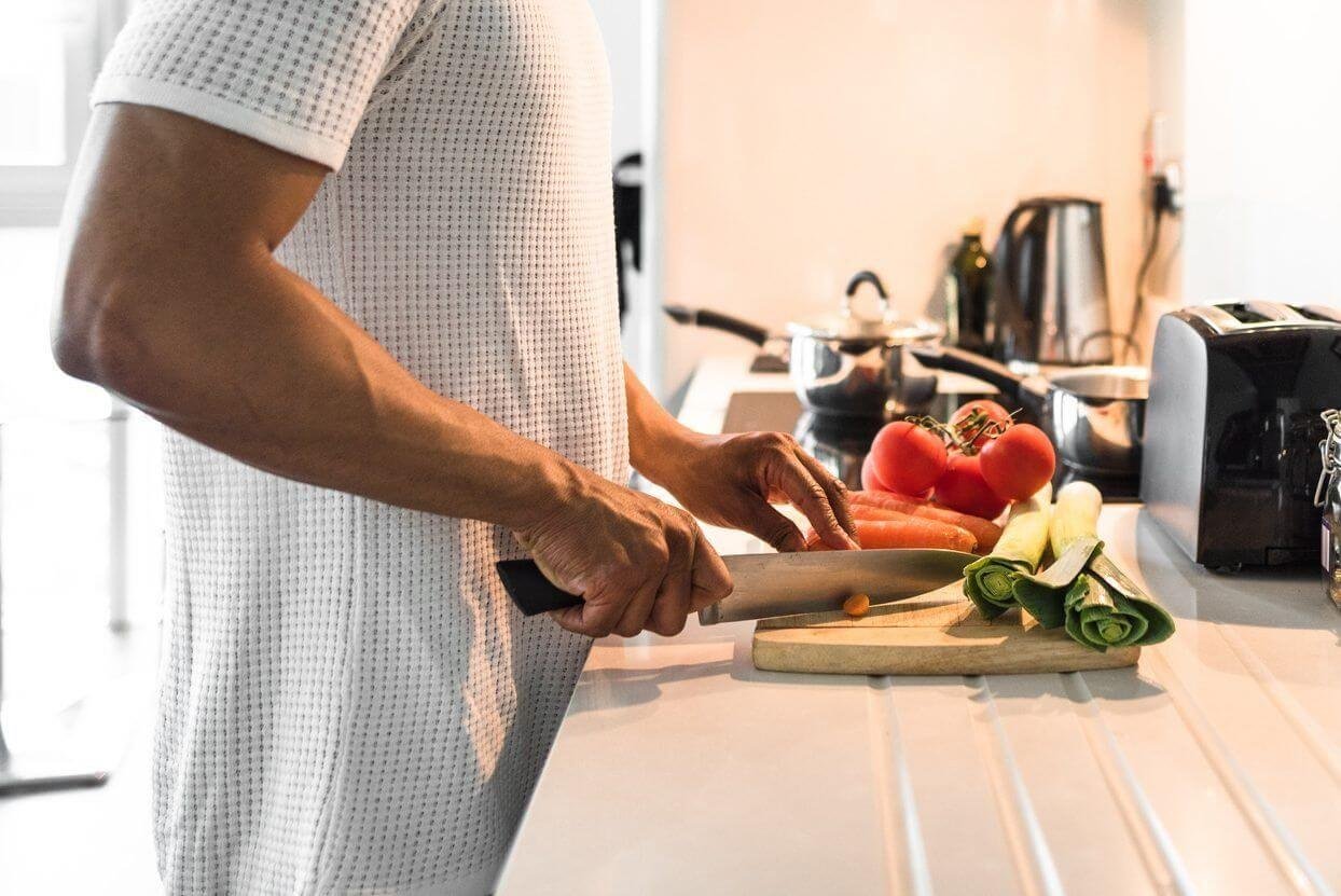 Daily Living Aids for Independence-Someone using a safety cutting board in the kitchen
