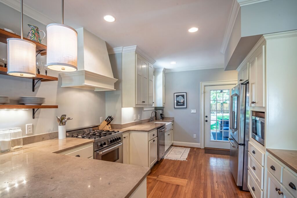 Bright, accessible kitchen with wide walkways, hardwood floors, lower countertops, and ample space for safe mobility and independent living.