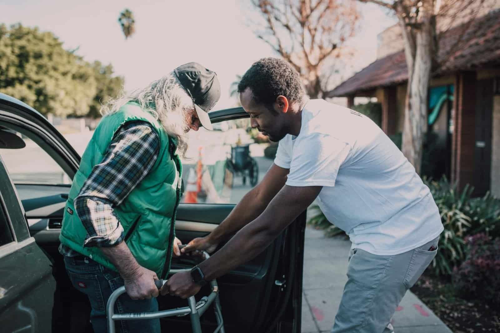 caregiver helping senior use walker getting out of car