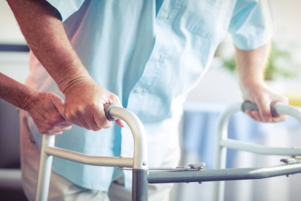 A man being helping who is on a walker