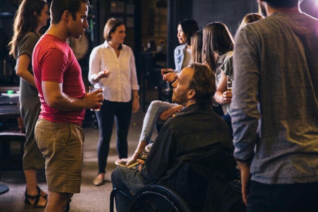 Man in a wheelchair with a group of friends at a party