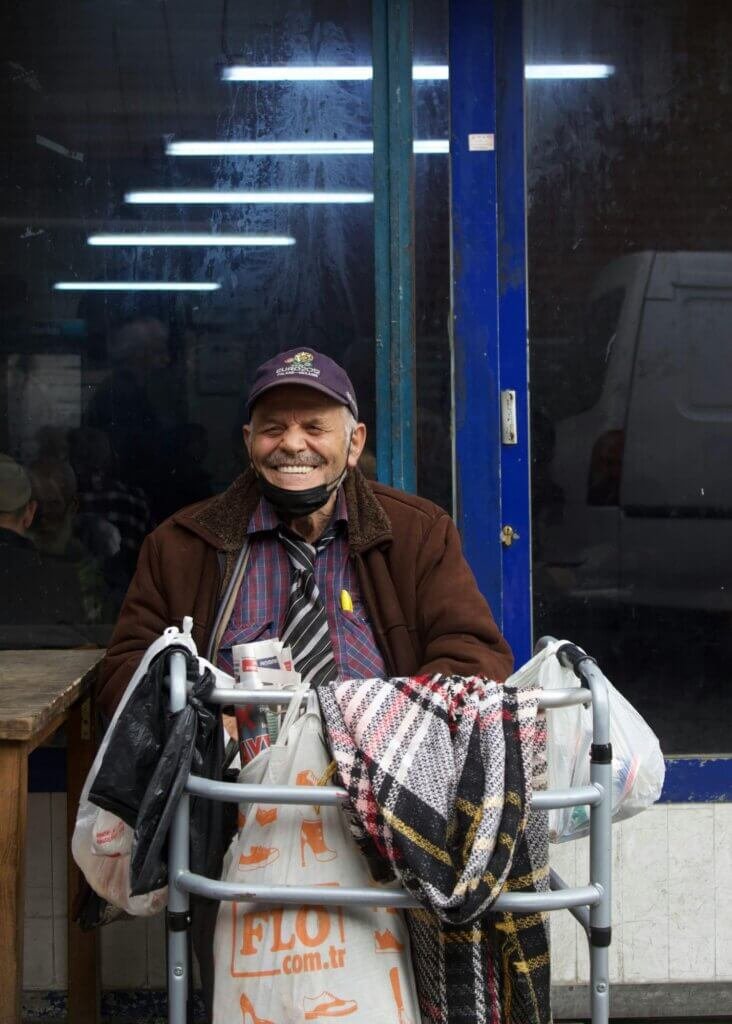 Man sitting with his walker smiling looking very happy