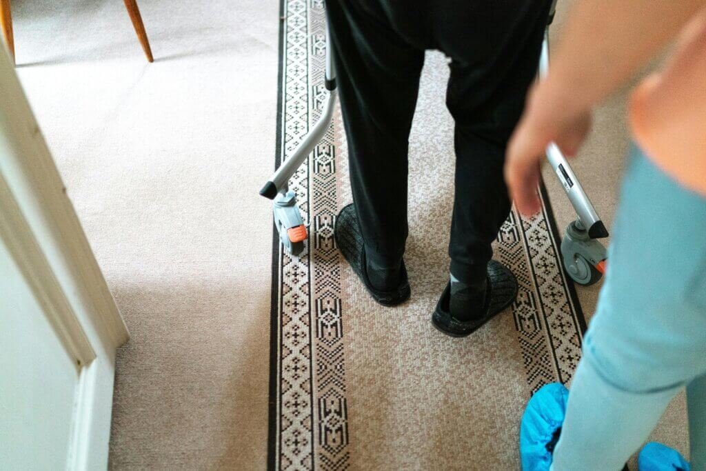 Older gentleman walking on carpet with a walker
