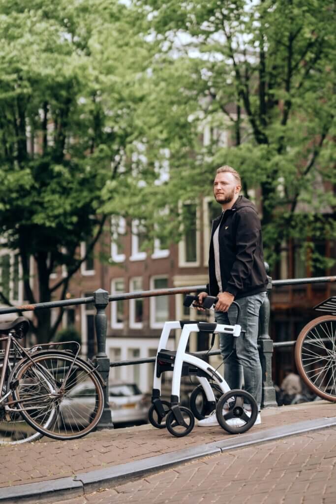 young man using a walker rollator outside