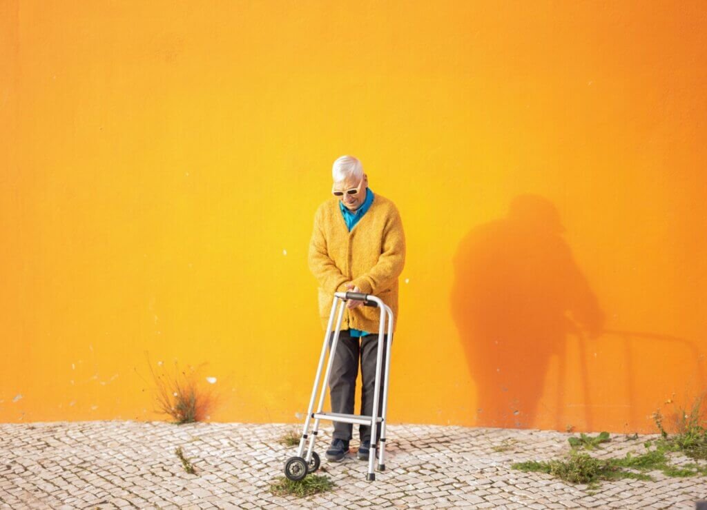 Older adult using a walker outdoors while maintaining mobility and independence.