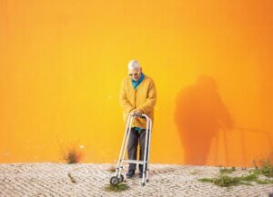Older adult using a walker outdoors while maintaining mobility and independence.