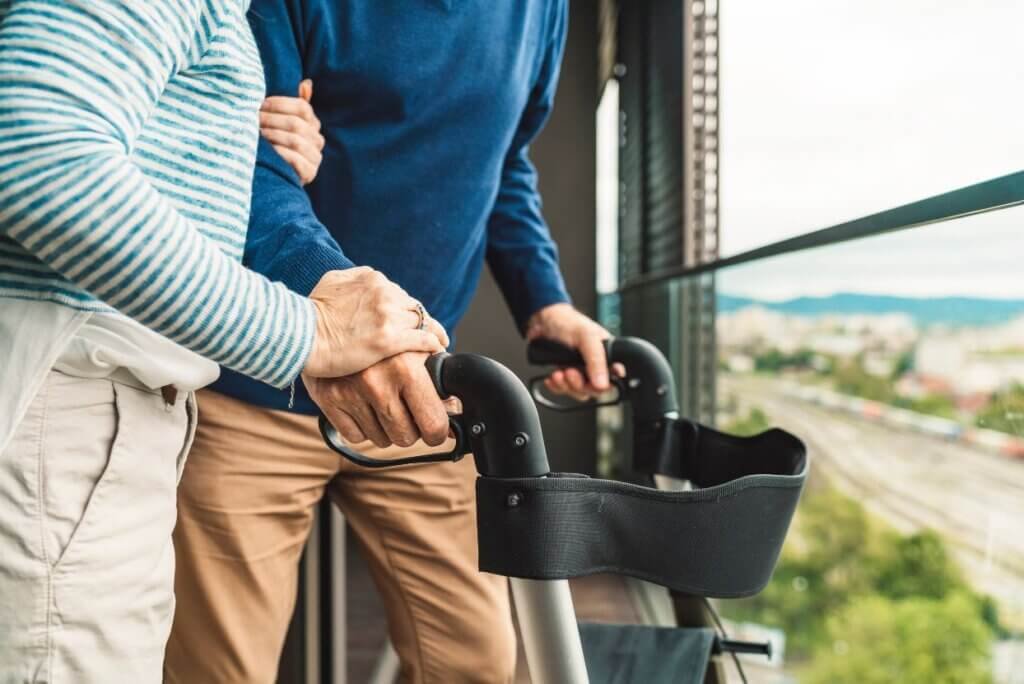 A woman helping her husband with his walker