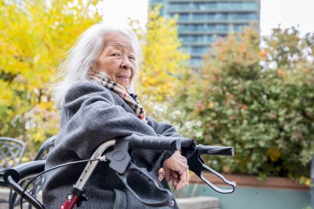 Are Walkers Covered by Medicare? _ lady sitting in her walker outside smiling 