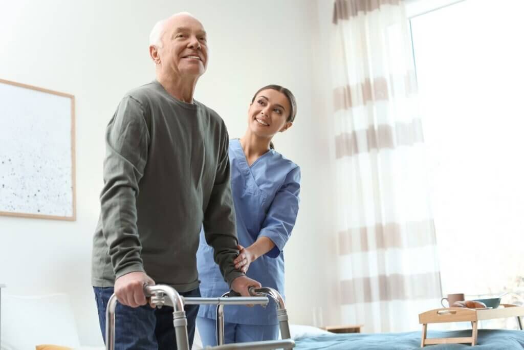 Are Walkers Covered by Medicare? A man being help by a nurse with his walker