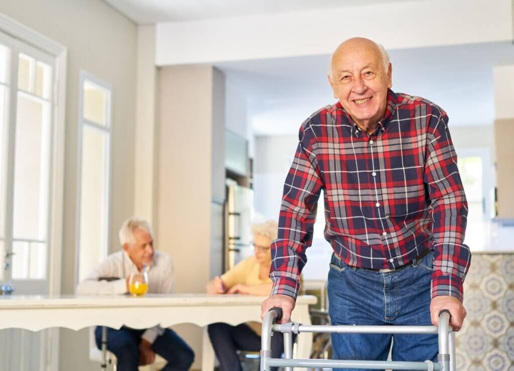 When Is It Time to Start Using a Walker?-Smiling senior man using a walker at home while maintaining independence and mobility.
