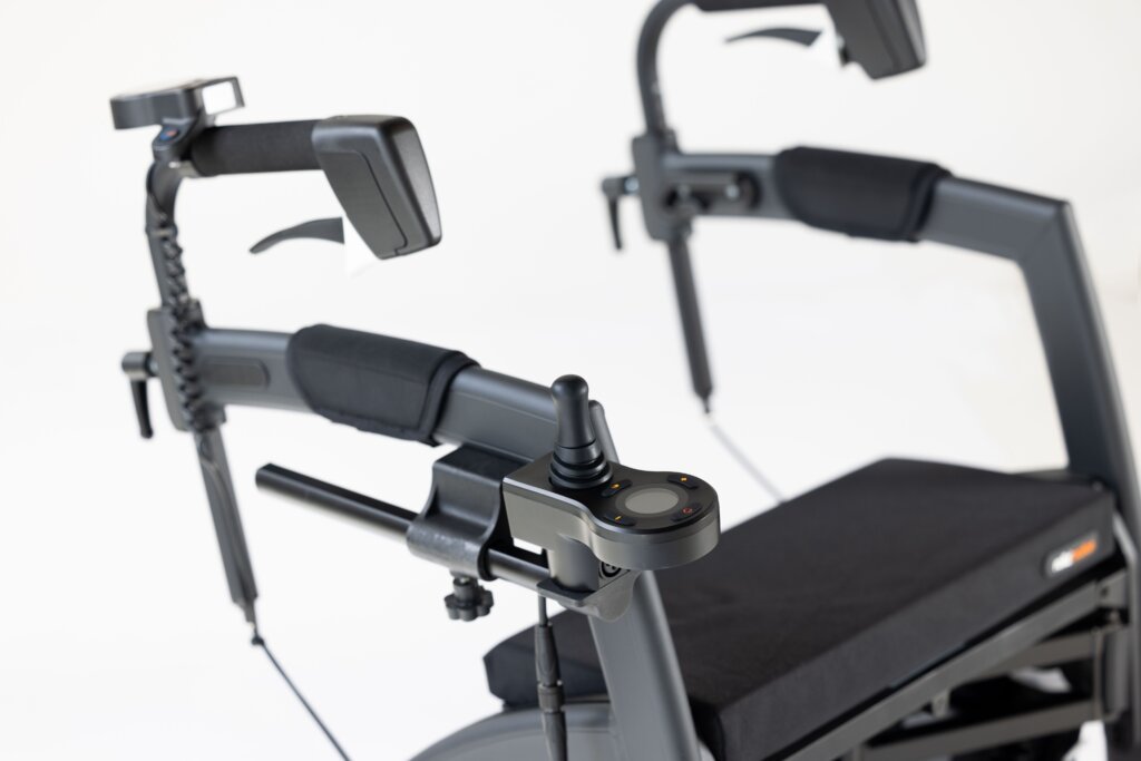 What Is a Rollator Walker?-Detailed close-up of an upright rollator walker featuring adjustable forearm supports, ergonomic hand brakes, electronic joystick control, and a padded seat designed for improved posture and mobility support.