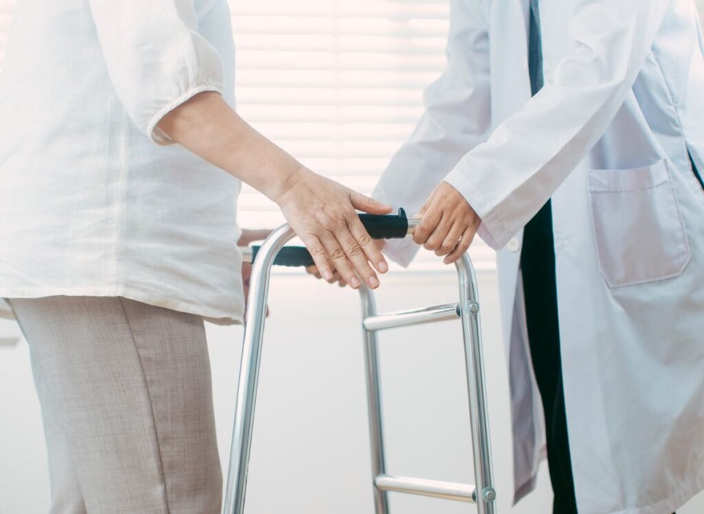 Healthcare professional assisting a senior with a walker during a medical evaluation for mobility support.