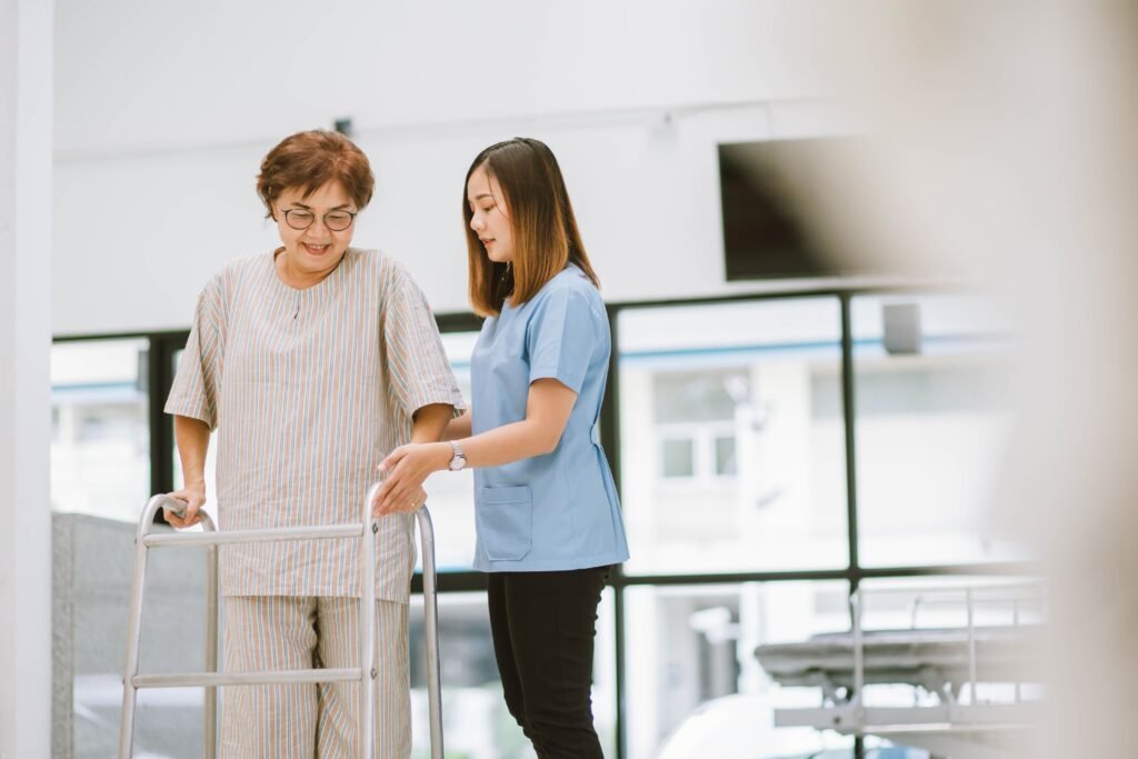 Best Walker for Arthritis ;Physical therapist helping a patient safely learn to walk with a standard walker during rehabilitation.
