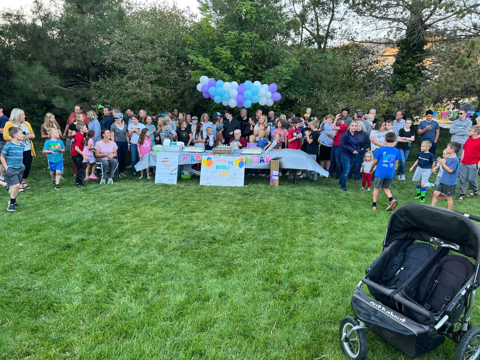 Ron's father celebrating his 102nd birthday at a surprise outdoor party hosted by his church ward, surrounded by family, friends, and community members.