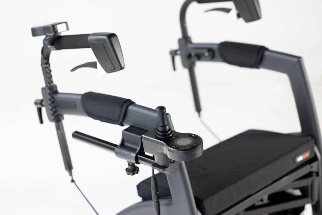 What Is a Rollator Walker?-Detailed close-up of an upright rollator walker featuring adjustable forearm supports, ergonomic hand brakes, electronic joystick control, and a padded seat designed for improved posture and mobility support.