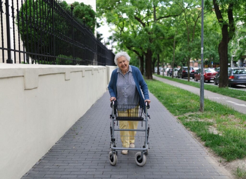 Senior using a rollator walker on a sidewalk outdoors