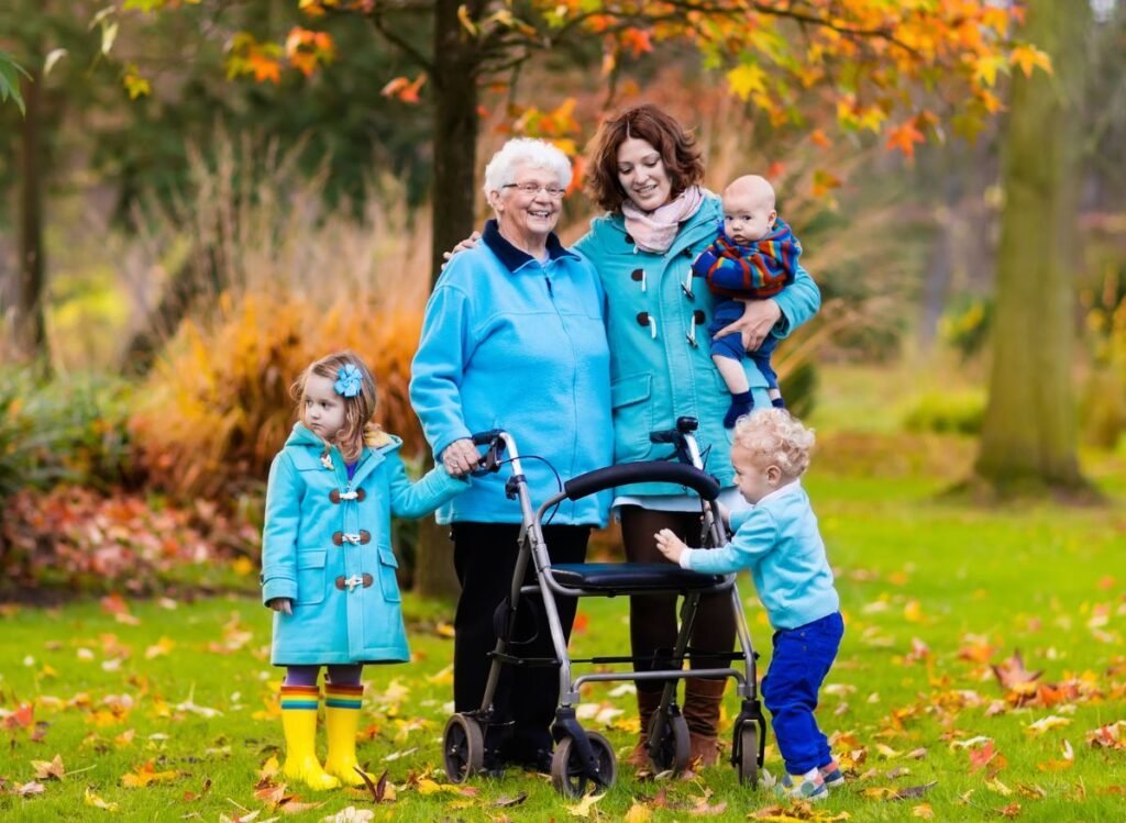 Senior using a rollator walker while spending time with family outdoors