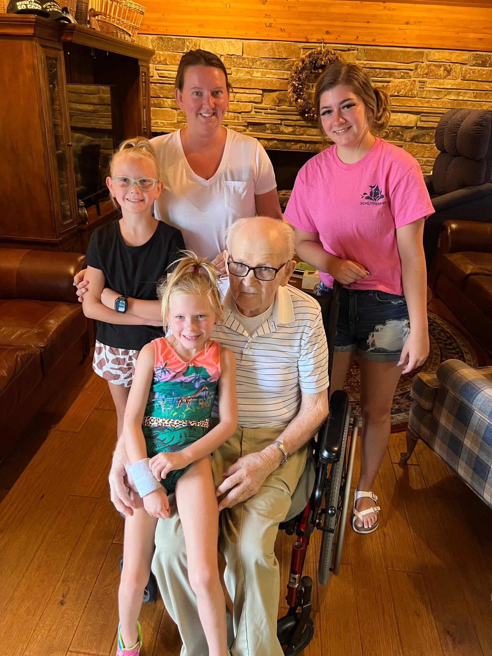 Ron's father sitting in a wheelchair with his granddaughter, great-granddaughter, and great-great-granddaughters during a family gathering, showing the importance of family support and staying connected across generations.