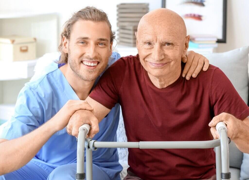 Man on a walk with his caregiver smiling at the camera-Daily Living Aids