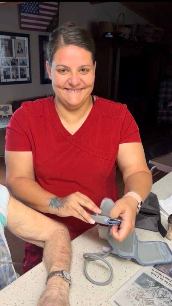 Do You Have Help With Your Dad?-Jessica, my dad’s longtime CNA, smiling while preparing a blood pressure cuff during an in-home care visit.